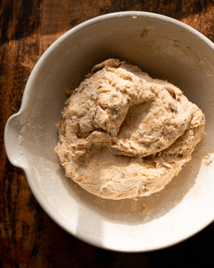 An overhead shot shows a shaggy bread dough in a large bowl.