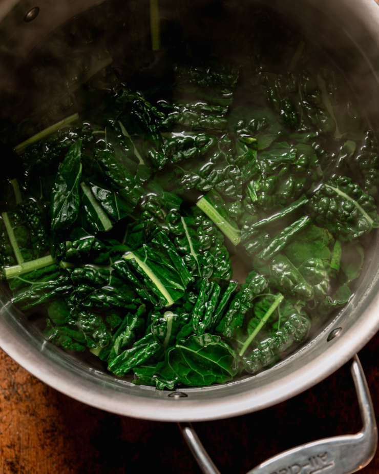 An overhead shot shows boiled kale in a stockpot.
