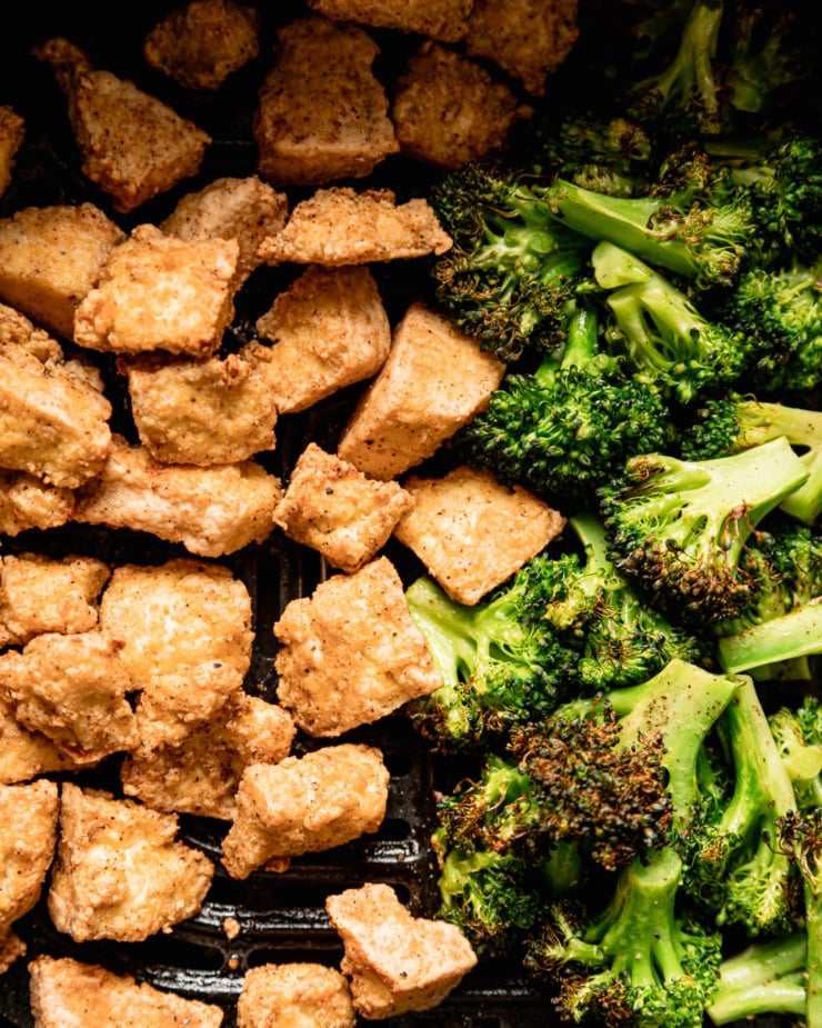 An up close, overhead shot shows air fried tofu nuggets and slightly charred broccoli florets.