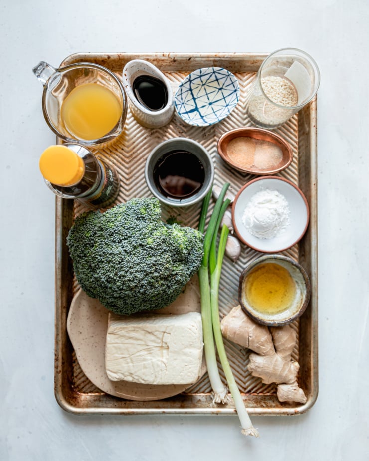An overhead shot shows ingredients for teriyaki tofu with broccoli, all arranged on a sheetpan.