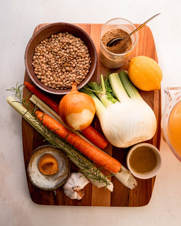 An overhead shot shows ingredients on a cutting board for a soup.