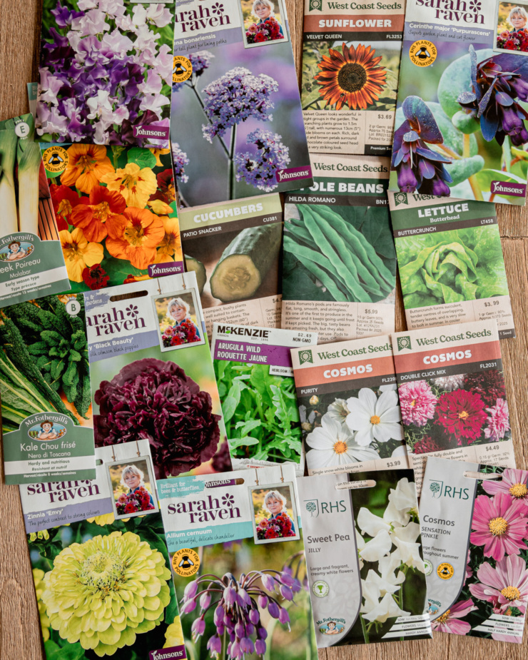 An overhead shot shows a bunch of seed packets--a mix of vegetables and flowers.