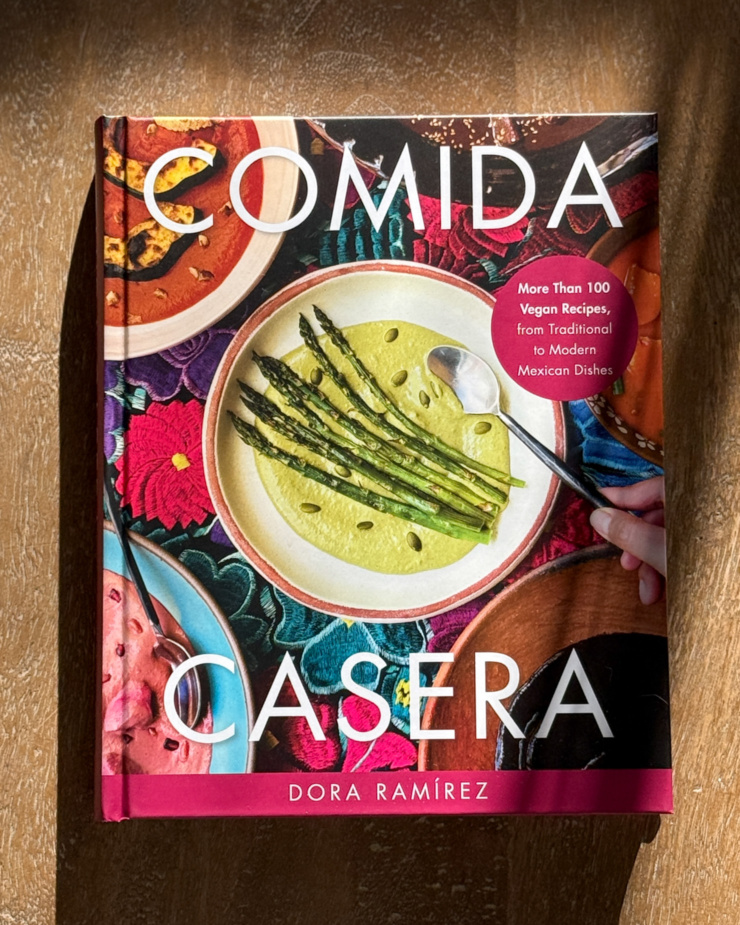 An overhead shot shows the cover of the cookbook "Comida Casera" by Dora Ramírez.