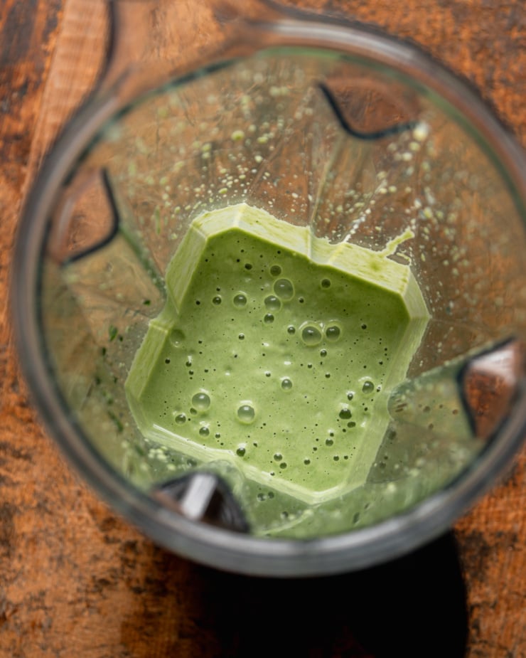 An overhead shot shows an edamame, cashew, and spinach purée in a blender pitcher.