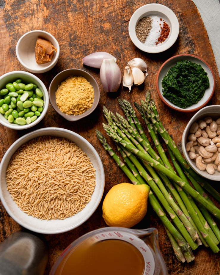 An overhead shot shows ingredients for a spring green orzo risotto with asparagus.