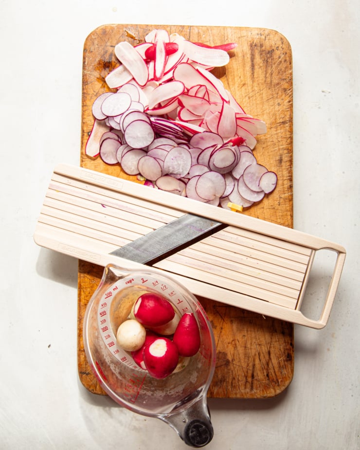 An overhead shot shows a cutting board with a mandoline slicer and sliced radishes.