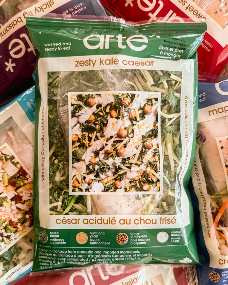 An overhead shot shows a bunch of bagged salads by the brand arte. The vegan kale caesar is front and center.