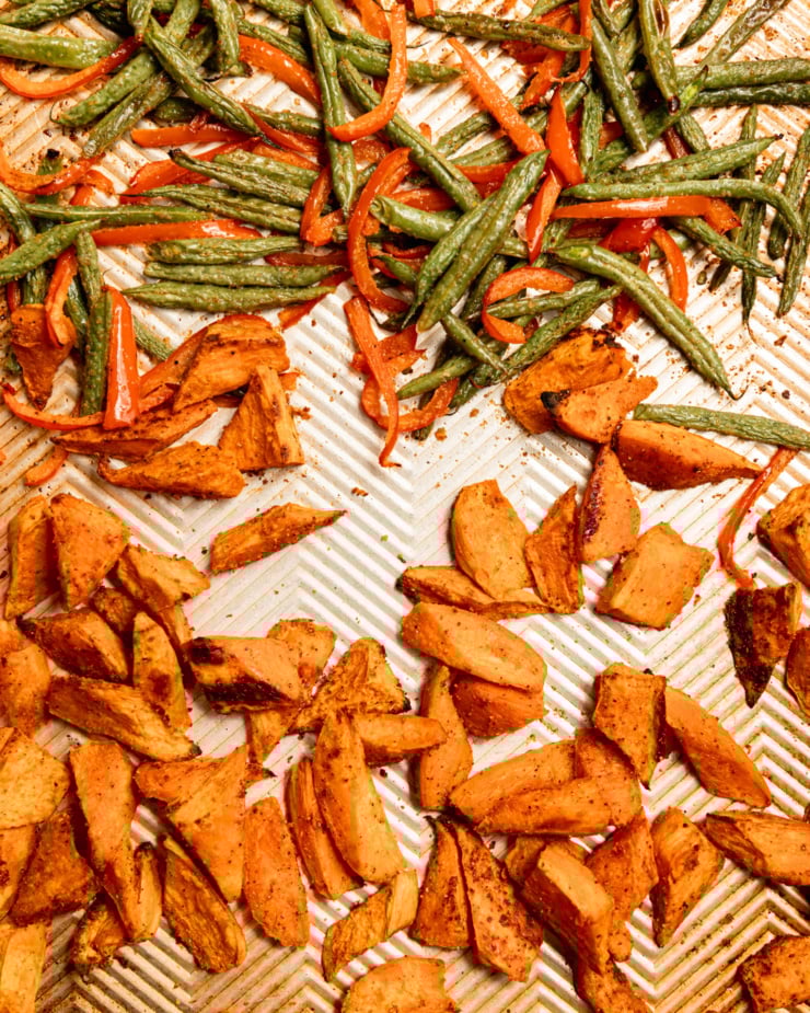 An overhead shot shows roasted sweet potato pieces, green beans, and sliced red bell pepper on a baking sheet.