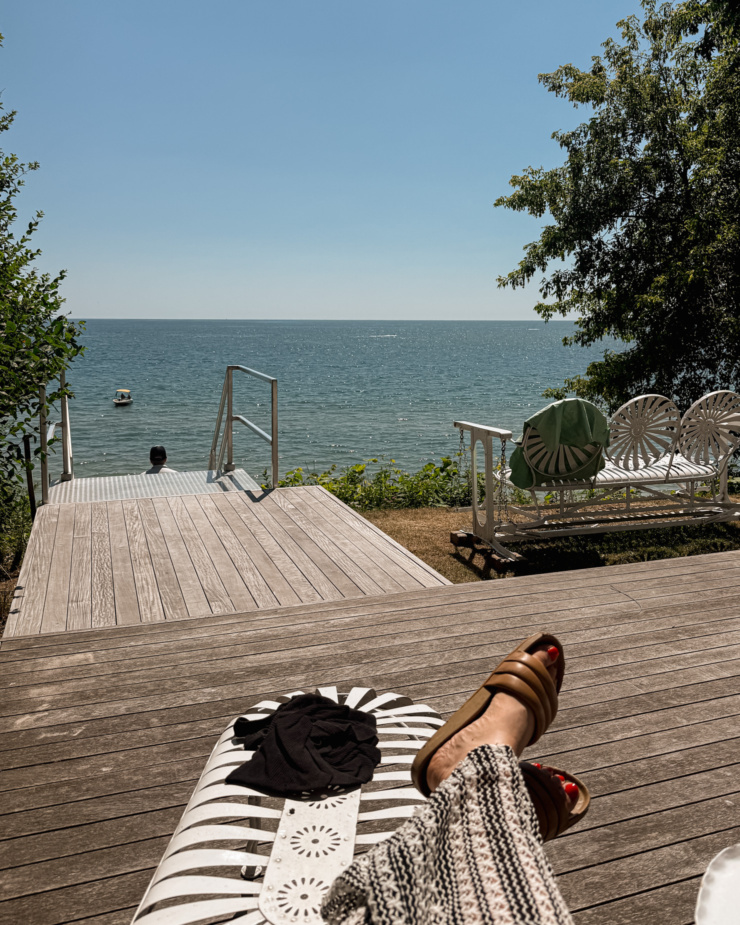 A head-on shot shows a deck and swing bench with a lake in the distance.