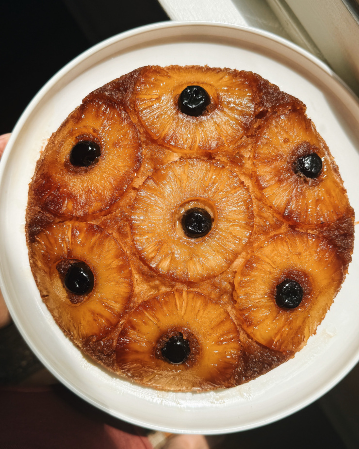 An overhead shot shows a pineapple upside down cake in bright, direct light.