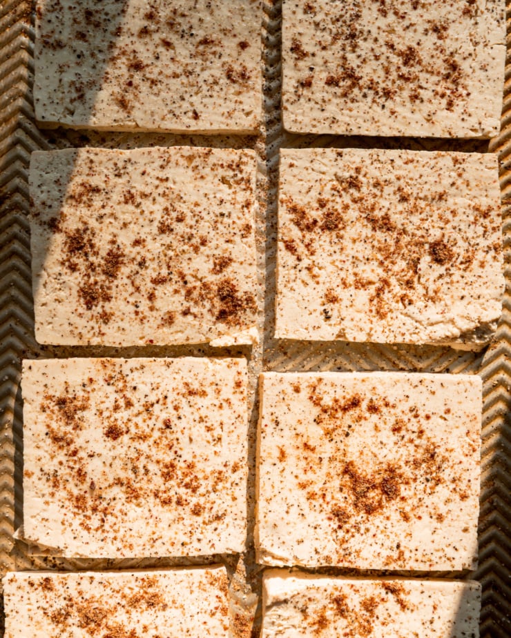 An up close, overhead shot shows square tofu slices dusted with spices.
