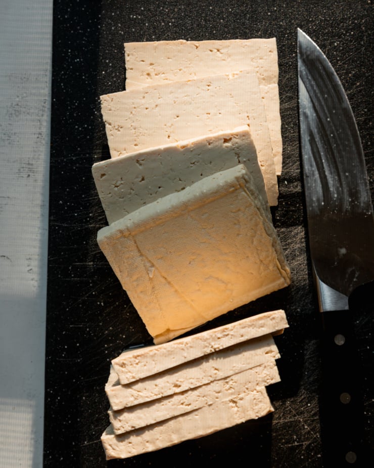 An overhead shot shows a sliced brick of firm tofu.