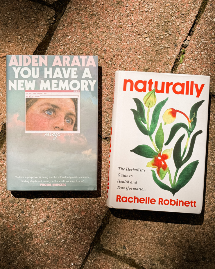 An overhead shot shows 2 books: Aiden Arata's "You Have a New Memory" and Rachelle Robinett's "Naturally"
