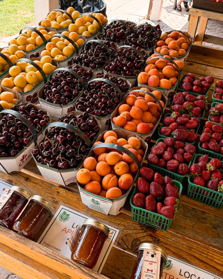 An overhead shot shows a bunch of baskets of fruit at a farm stand.