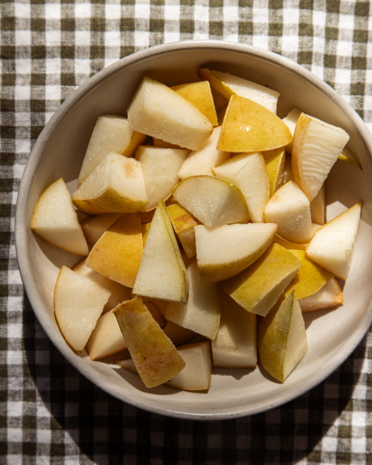 An overhead shot shows a bowl of frozen pear chunks in a bowl.