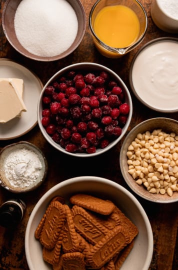 An overhead shot shows ingredients needed for a vegan cranberry tart with white chocolate and Biscoff crust.