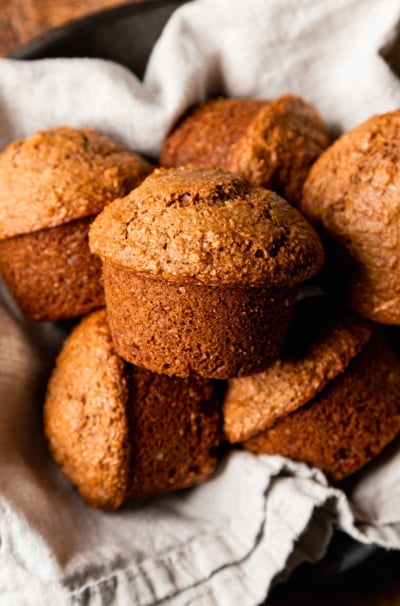 An overhead shot shows vegan bran muffins nestled into a linen-lined bowl.