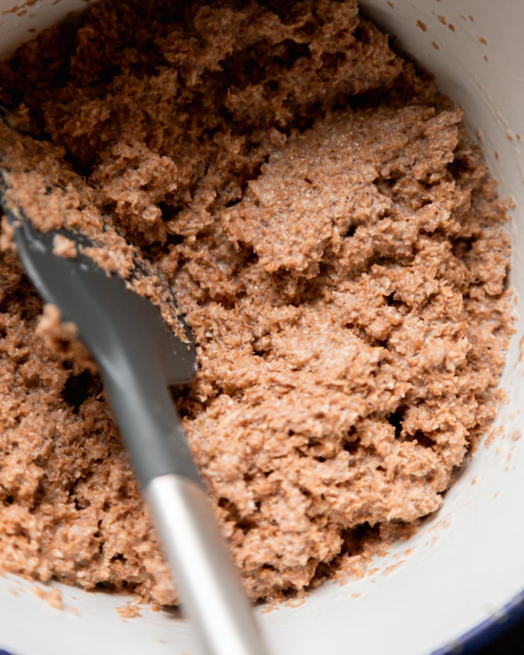 An overhead, up close shot shows wheat bran thoroughly soaked in a vegan "buttermilk" mixture.